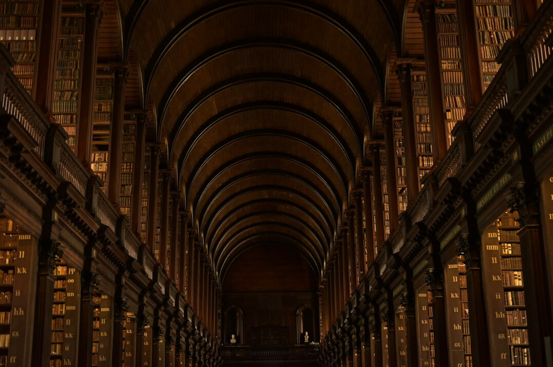 Old library with tall wooden bookshelves and warm light